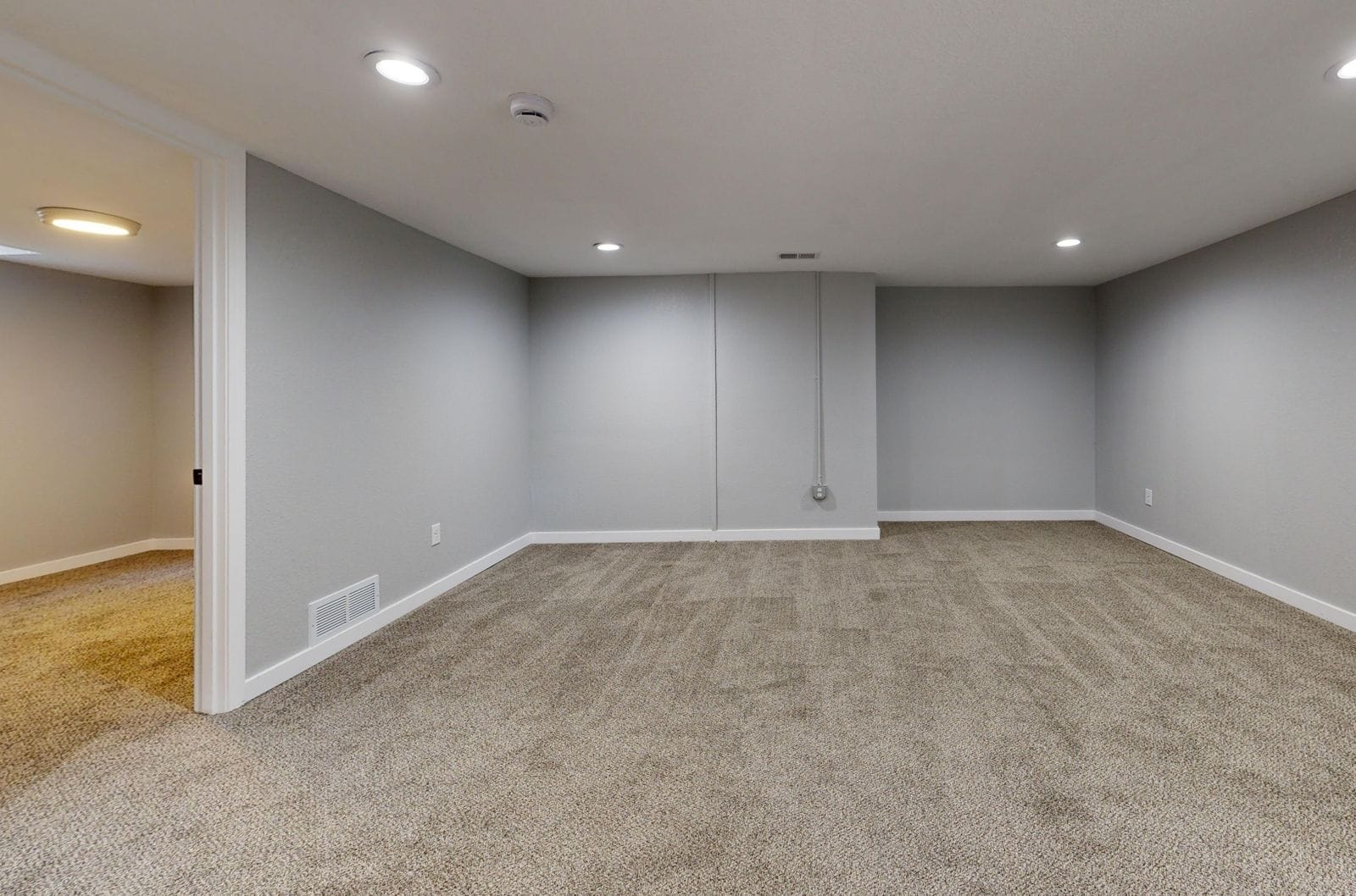 A finished basement with painted walls and a coated floor
