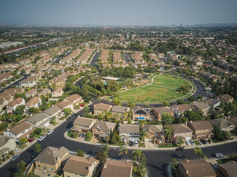 A residential community of similar houses laid out around a central green