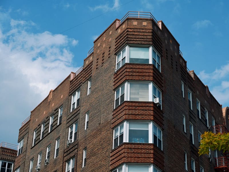 A brick low-rise residential block with projecting bay windows