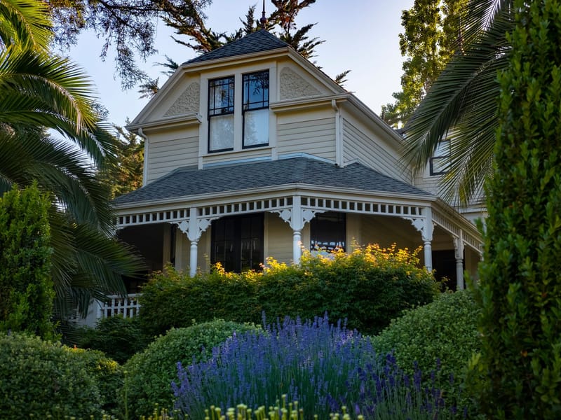 A Victorian house with decorative eave brackets and a wraparound porch