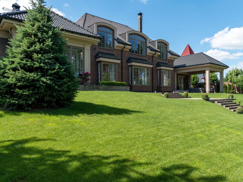 A large house with arched windows and a wide manicured lawn