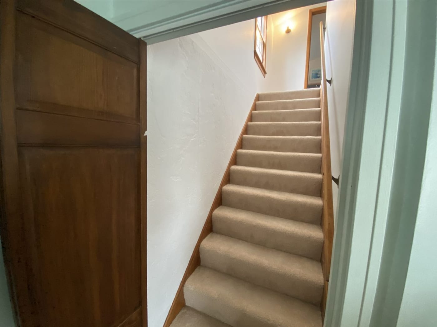 A repainted stairway with the stained handrail and stringer left as they were