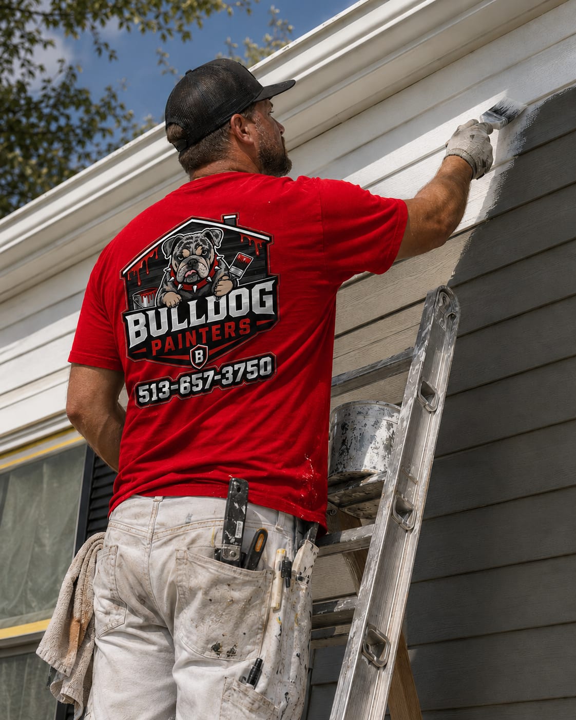 A Bulldog Painters painter on a ladder cutting in fresh paint on a home exterior