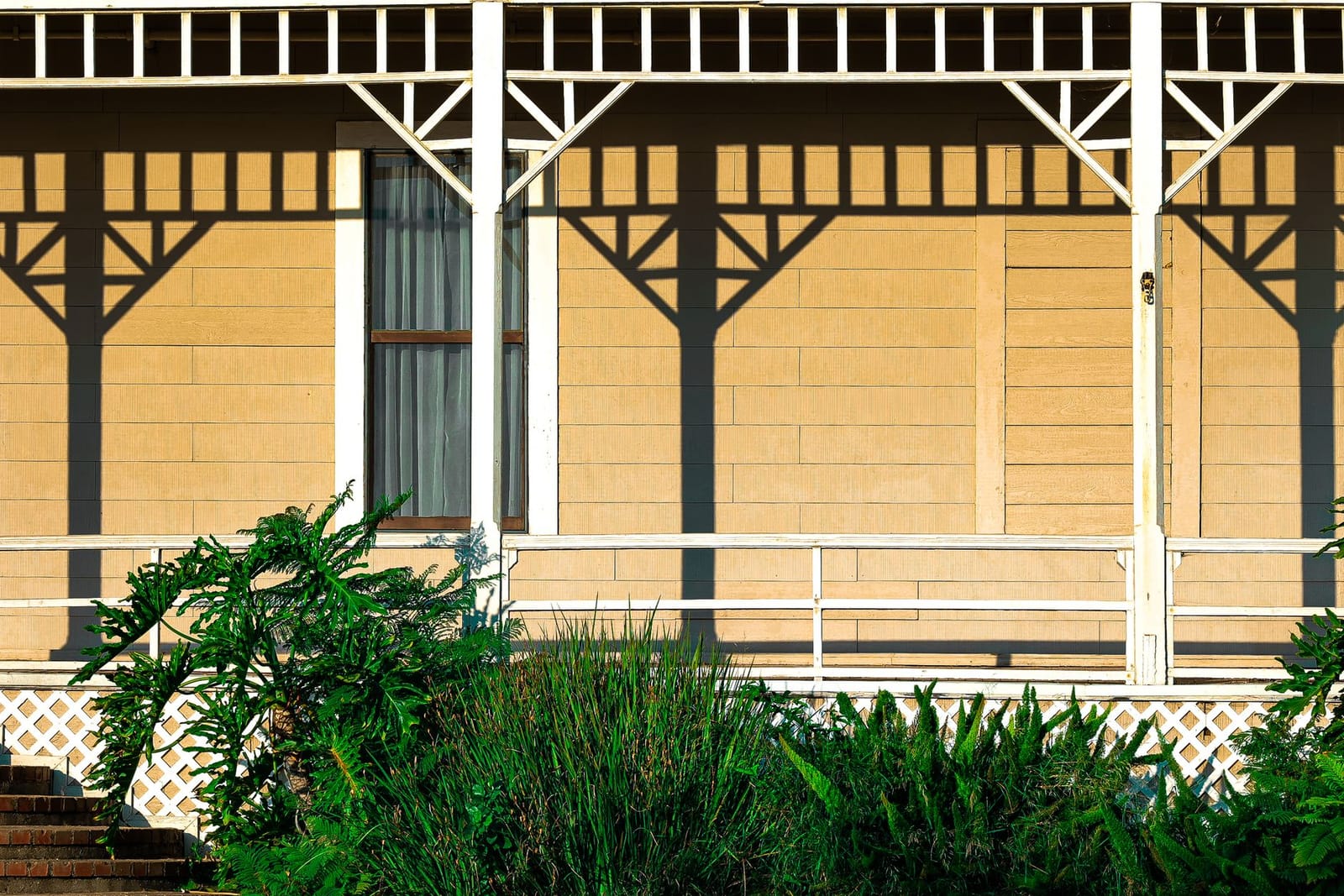 A porch with painted columns, railings and ceiling